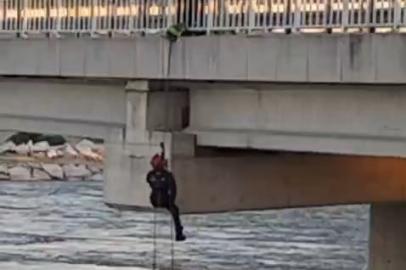 Köprü altında asılı kalan güvercini halatla inip kurtardılar